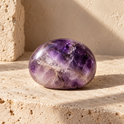 Sensorium Amethyst — Stillness, polished amethyst on warm travertine