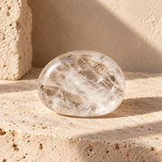 Sensorium Clear Quartz — Clarity, polished clear quartz on warm travertine