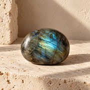 Sensorium Labradorite — Transformation, polished labradorite on warm travertine